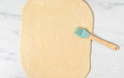 Пласт теста смажьте маслом. Это удобнее делать ладонью, но можно использовать и силиконовую кисточку.