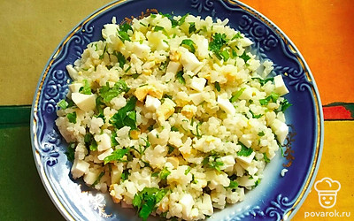 Сварить рис. Выложить сливочное масло. Отварить 3 яйца, охладить, нарезать. Измельчить петрушку, посолить, все перемешать.