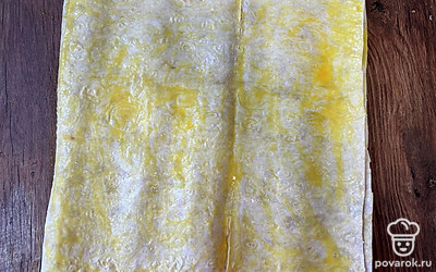 Лаваш разрежьте пополам. Смажьте 1 лист взбитым яйцом. Затем на него положите второй лист лаваша и тоже смажьте яйцом.