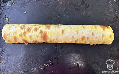 Сверните в рулет и смажьте яйцом. Отправьте в разогретую до 190 градусов духовку на 40 минут.