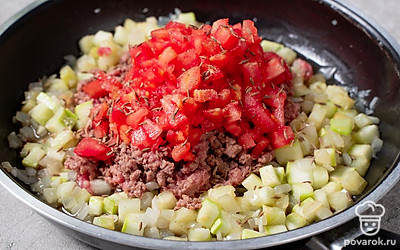 Выложите помидор к мясу с овощами, всыпьте зиру и кориандр. Перемешайте начинку, закройте крышку и тушите еще 10 минут, пока вся жидкость не выпарится.