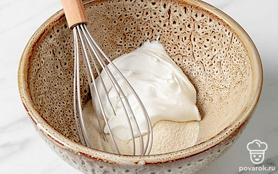 Насыпьте манку в миску. Добавьте сметану, хорошо перемешайте. 