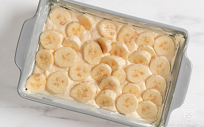 Выложите в форму тесто, а сверху разложите кружочки двух бананов. Отправьте манник в духовку на 50 минут.