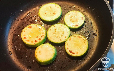 На разогретой сковороде, сбрызнутой оливковым маслом, поджарьте до румяной корочки ломтики кабачков. Добавьте соль по вкусу. 