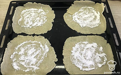 Тесто разделить на 4 части. Раскатать в пласты толщиной 3 миллиметра, каждый пласт посыпать крахмалом.