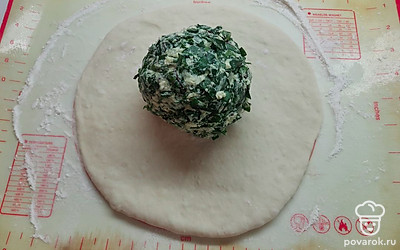 Каждый шарик теста раскатать в лепешку диаметром с большую тарелку. В центр выложить шарик начинки. 