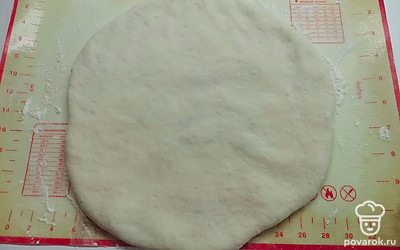 Шар перевернуть и руками размять в тонкую лепешку толщиной 6-8 миллиметров. 
