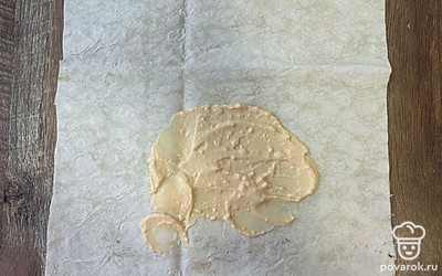 Разверните лист лаваша. Середину смажьте сырным соусом.