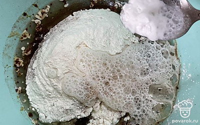 Добавляем соду, гашенную уксусом, и замешиваем тесто.