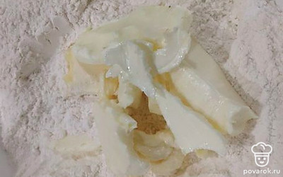 Насыпать в миску 250 грамм муки, выложить мягкое масло. 