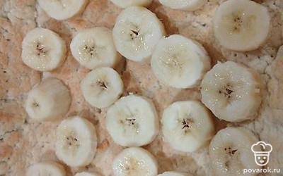 На тесто выложить нарезанные кружочками бананы.