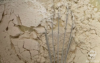 Постепенно введите просеянную муку.