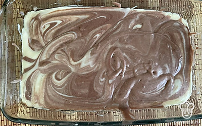 Форму смажьте сливочным маслом. В произвольном порядке заполните тестом форму. Зубочисткой сделайте узоры. Выпекайте пирог при 180 градусах 35 минут.