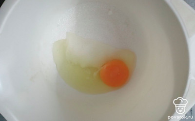 Готовим заварной крем. В глубокую чашу разбиваем 1 яйцо и добавляем 80 граммов сахара. Хорошо взбиваем венчиком. 
