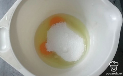 Готовим тесто. В глубою чашу разбиваем 2 яйца и добавляем 150 граммов сахара. Хорошо взбиваем венчиком. 