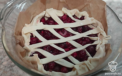 Из остатков слоеного теста раскатайте тонкие полоски и украсьте пирог.