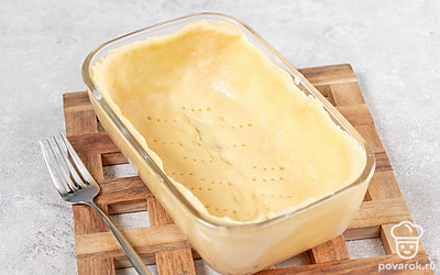 Поставьте разогреваться духовку до 180 градусов. Утрамбуйте тесто в форму, сделайте высокие бортики. Наколите тесто вилкой несколько раз. Уберите форму в холодильник еще на 20 минут, затем выпекайте 15 минут в духовке. 