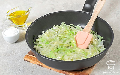 Приготовьте начинку. Капусту нашинкуйте, а лук нарежьте мелкими кубиками. Сковороду с маслом разогрейте. Добавьте овощи и обжарьте на среднем огне 8-10 минут. В конце приправьте начинку специями.