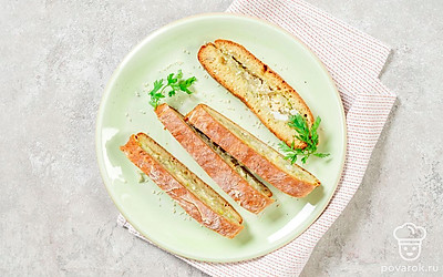 Выложите готовый пирог на большую тарелку и разрежьте на порционные кусочки. Украсьте семенами кунжута и веточками петрушки.