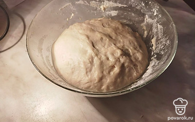 Когда тесто увеличится в объеме в 2 раза, можно начинать формировать пирог. Разделяем тесто на 2 неравные части.