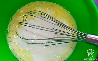 Смешиваем 2 яйца с сахаром (200 г) и щепоткой соли. Сахар кладем по вкусу, учитываем, что он нужен для начинки. Ставим разогреваться дуговку до 180 градусов. Добавляем кефир, перемешиваем венчиком.