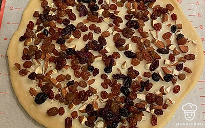 Каждый корж смажьте столовой ложкой сгущеного молоко, посыпьте измельчёнными орехами и изюмом.