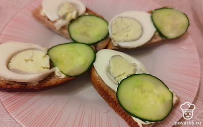 Огурец выложите на хлеб рядом с яйцом.