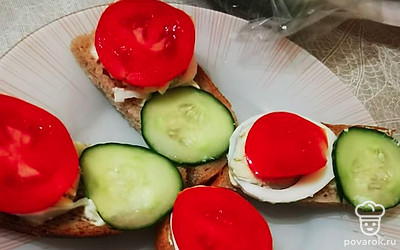 Выложите помидор на яйцо.