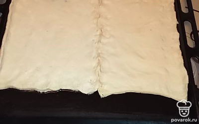 Тесто полежало при комнатной температуре, стало эластично и податливо. Промазываем растительным маслом противень, раскладываем, растягивая тесто руками. Можно соединить два пласта, можно сделать бортик как у пирога.