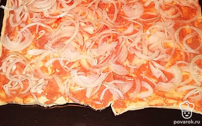 Смешиваем кетчуп с майонезом, промазываем соусом основу пирога. Сверху раскладываем слой нашинкованного репчатого лука. 