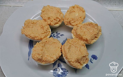 Нафаршируйте полученной начинкой яйца, сделав небольшое углубление. 