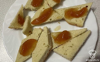 Разрезаем готовый пирог на кусочки. Каждый смазываем вареньем.