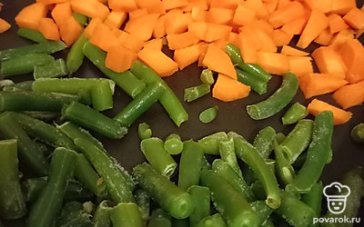 Замороженную стручковую фасоль и нарезанную кубиками морковь тушить на среднем огне.
