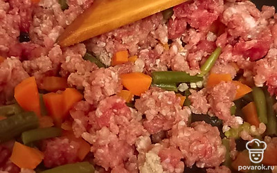 Добавить в овощи фарш, посолить. Приправить любимыми специями, перемешать и оставить готовиться порядка 20 минут.
