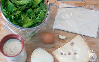 Подготовьте ингредиенты. Шпинат вымойте и откиньте на сито, чтобы стекла лишняя вода. Тесто разморозьте примерно 1 час при комнатной температуре, предварительно завернув в пищевую пленку.