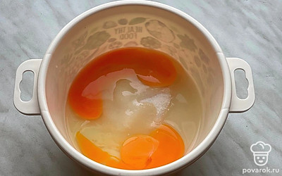 В большую емкость для приготовления теста разбейте 2 яйца. Добавьте к ним сахар, взбейте венчиком.
