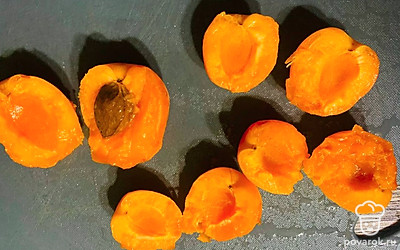 Промойте абрикосы, разрежьте пополам и удалите косточки.