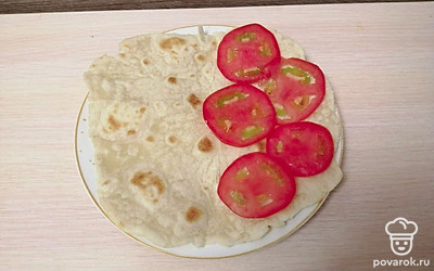 На одну половину лаваша круглой формы выложите помидоры.