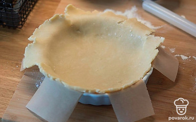 Когда пройдет час, раскатайте тесто по размеру формы диаметром 22 сантиметра + 2 сантиметра на бортики. Тесто ломкое, поэтому переносить его удобно, намотав на скалку и размотав его над формой.