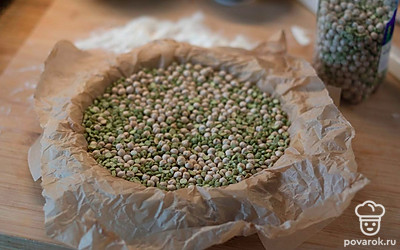 Накройте тесто бумагой, выложите груз (любые бобовые) и отправьте на 15 минут при 190 градусах. Потом уберите груз и отправьте основу еще на 5 минут в духовку.