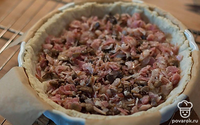 Соберите киш: выложите на дно начинку (грибы и бекон).