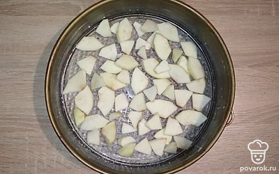 Снимите цедру с лайма. Выжмите сок. Форму для выпекания смажьте сливочным маслом, затем посыпьте сахаром. Очищенные яблоки порежьте на дольки, выложите их на дно формы. Сверху сбрызните соком лайма.