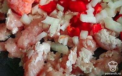 На сковороде минут 5 обжарьте куриный фарш. Затем мелко нарежьте лук репчатый и красный перец. Натрите морковь. Все соедините и жарьте еще минут 5-7. 