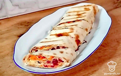 Концы рулета обрежьте наискось. Лаваш нарежьте по диагонали. Сложите в овальное блюдо.