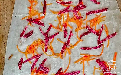 Колбасу нарежьте соломкой и посыпьте поверх моркови.