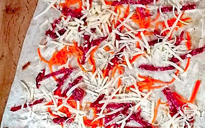 Сыр натрите на крупной терке. Распределите поверх колбасы.