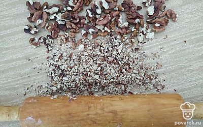 Разотрите орехи скалкой или блендером. На плоское блюдо положите блин и смажьте его сгущенкой, посыпьте измельченными грецкими орехами, накройте следующим блином.