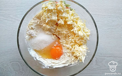 Натрите на крупной терке в миску сливочное масло, добавьте сахар, соль, яйцо, всыпьте муку с разрыхлителем и замесите мягкое песочное тесто. Оберните его пищевой пленкой и поставьте в холодильник на 40 минут.