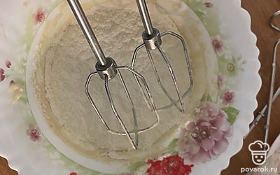 Перемешиваем венчиком, потихоньку вмешиваем 180 грамм просеянной муки.