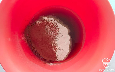 В большую миску вылейте теплый кофе, растительное масло и насыпьте сахар. Перемешайте ингредиенты до растворения сахара. Затем, в миску просейте через сито пшеничную муку и какао порошок. Перемешайте до однородного состояния.